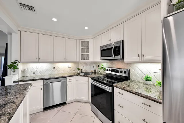 a kitchen with granite countertop a sink stove and cabinets