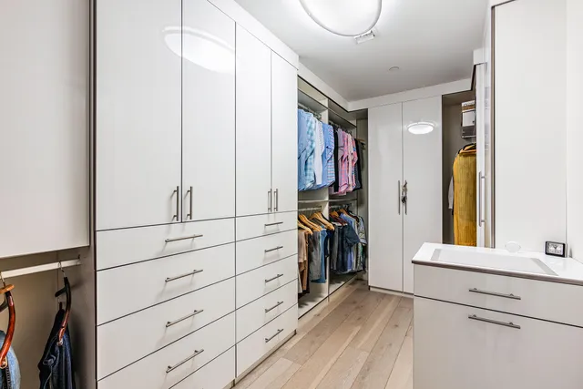 a view of walk in closet with clothes