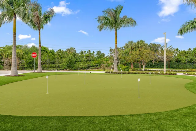 a view of a swimming pool with a yard and palm trees