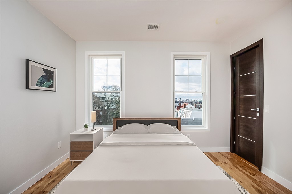 39 Lexington Street, Unit 9 Boston, MA 02128 - Photo 5 of 10 a spacious bedroom with a bed and a window