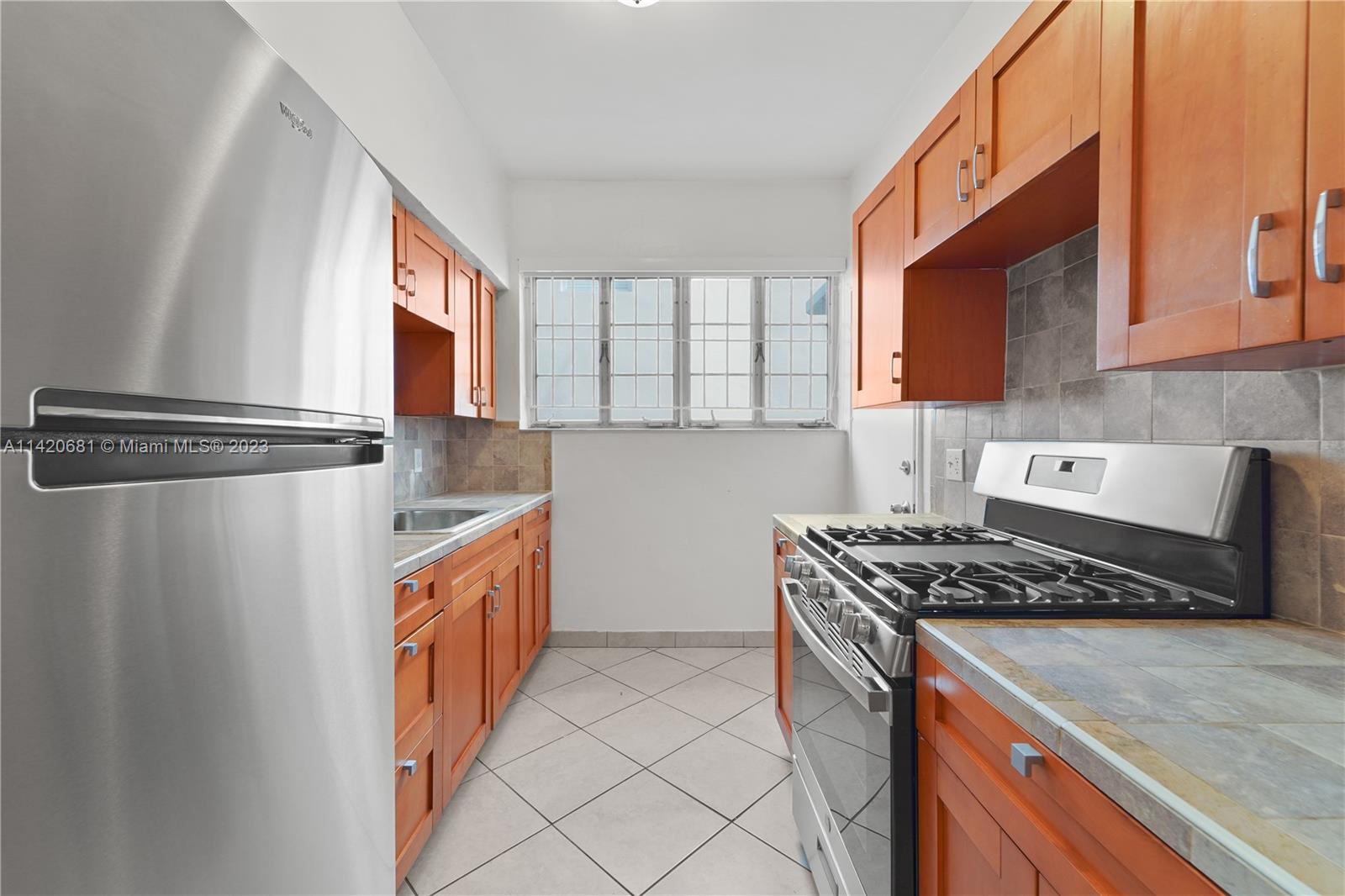 531 16th Street Miami Beach, FL 33139 - Photo 19 of 26 a kitchen with stainless steel appliances granite countertop a sink a stove and a refrigerator