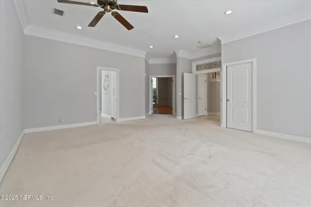 an empty room with a chandelier fan and closet area