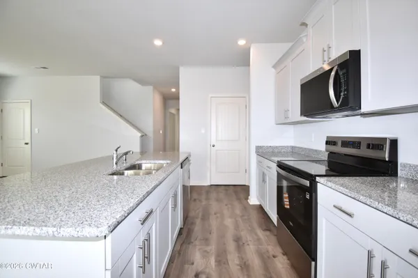 a kitchen with stainless steel appliances granite countertop a sink stove and microwave