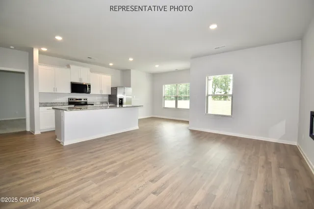 a view of kitchen with microwave a stove and wooden floor