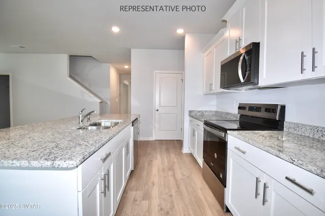 a kitchen with a sink stove top oven and refrigerator