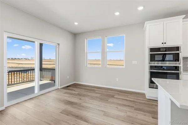 a view of kitchen with wooden floor and electronic appliances