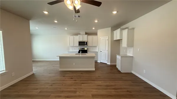 a large kitchen with kitchen island a sink stainless steel appliances and cabinets