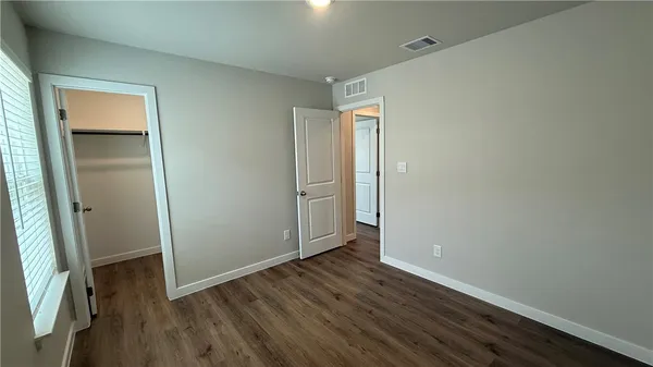 an empty room with wooden floor and closet