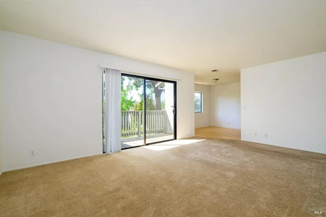 an empty room with an outdoor view and sliding door