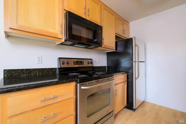 a kitchen with stainless steel appliances granite countertop a stove microwave and sink