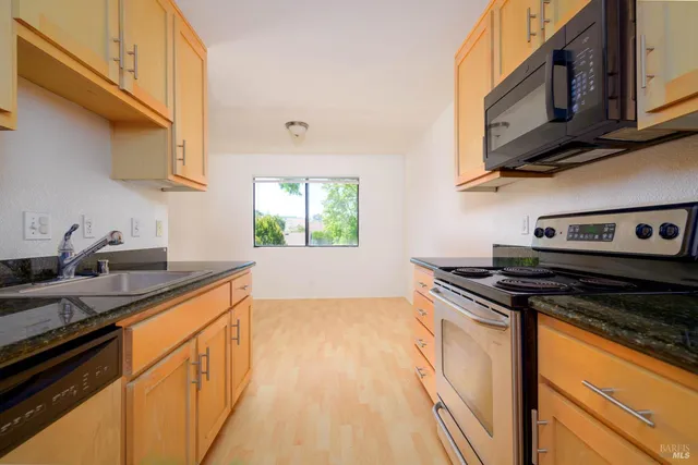 a kitchen with stainless steel appliances granite countertop a sink stove and cabinets