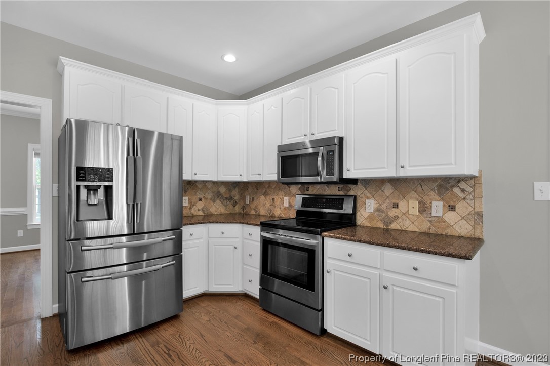 369 Grand Stand Lane Angier, NC 27501 - Photo 15 of 33 a kitchen with cabinets stainless steel appliances and wooden floor