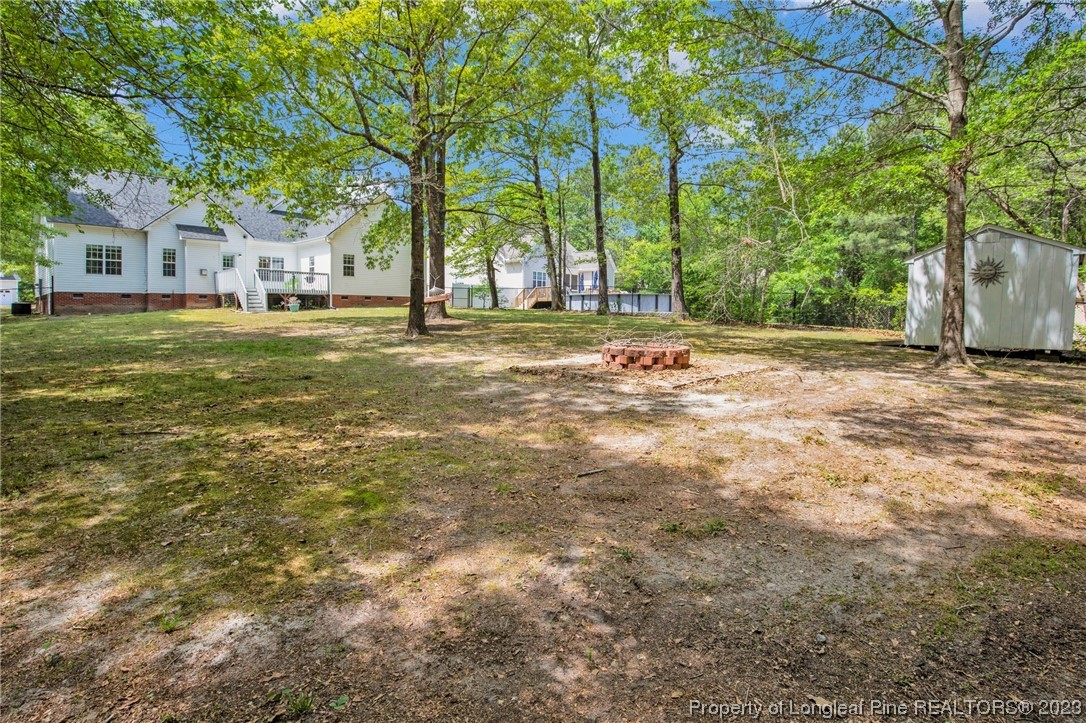 369 Grand Stand Lane Angier, NC 27501 - Photo 30 of 33 a backyard of a house with large trees and outdoor seating