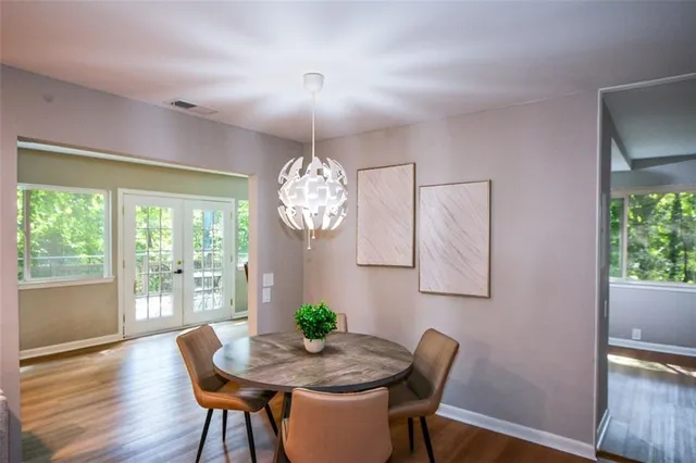 a view of a dining room with furniture a chandelier and wooden floor