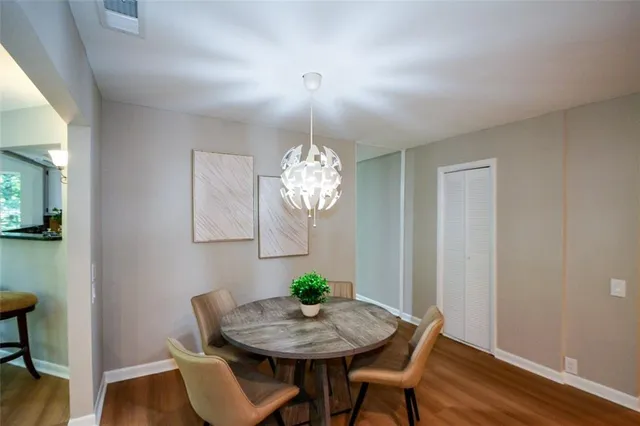 a view of a dining room with furniture a chandelier and wooden floor