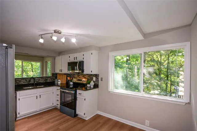 a kitchen with a large window appliances and cabinets