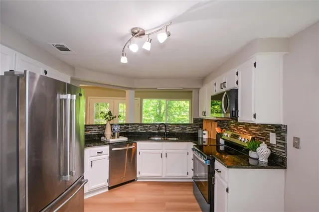 a kitchen with a refrigerator and a stove top oven
