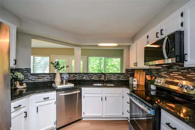 a kitchen with a stove a sink and a microwave
