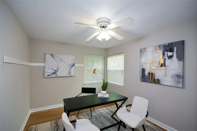 a view of a workspace with furniture and a chandelier fan