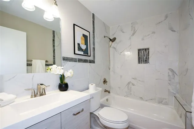 a bathroom with a sink a toilet and shower