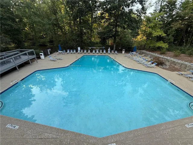 a swimming pool with trees in the background