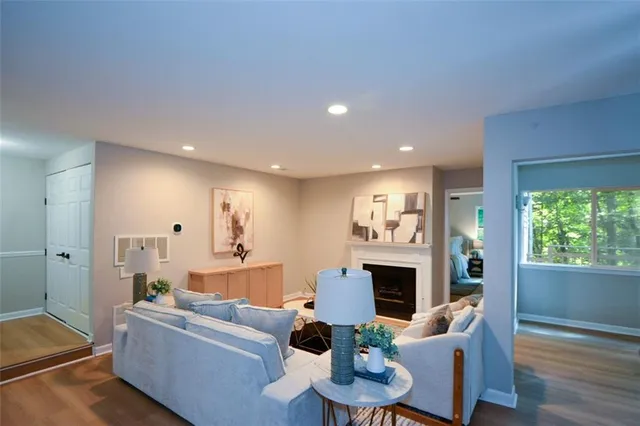 a living room with furniture a fireplace and a dining table with wooden floor