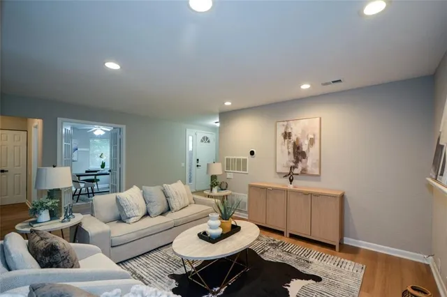 a living room with furniture and a wooden floor