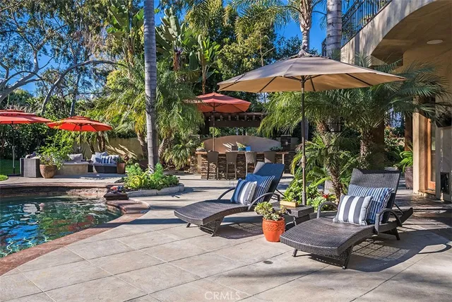 a view of a patio with couches chairs potted plants and floor to ceiling window