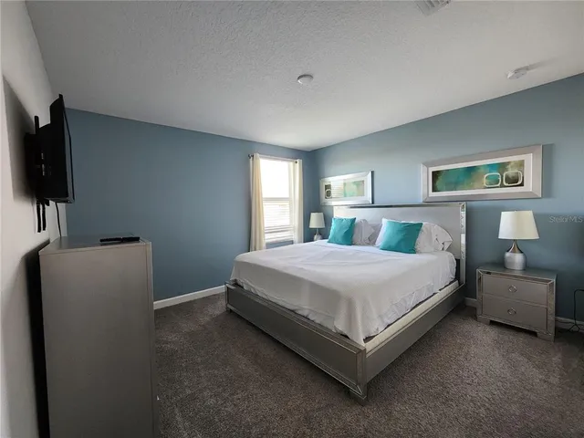 a bedroom with a bed and a flat screen tv
