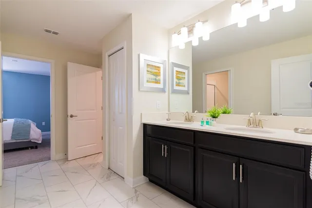 a en suite bathroom with a double vanity sink and a mirror