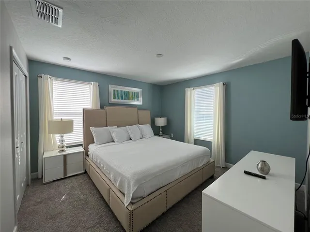 a bedroom with a bed and a flat screen tv