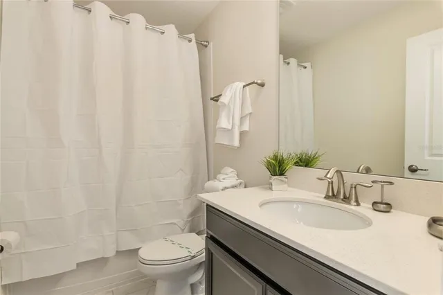 a bathroom with a granite countertop sink toilet and a mirror