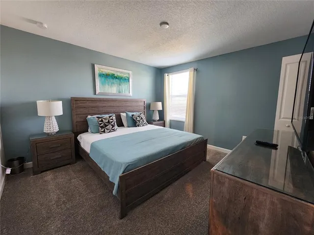 a bedroom with a bed lamp and a window