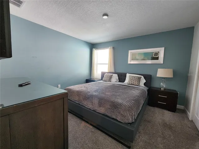 a bedroom with a bed and a night stand