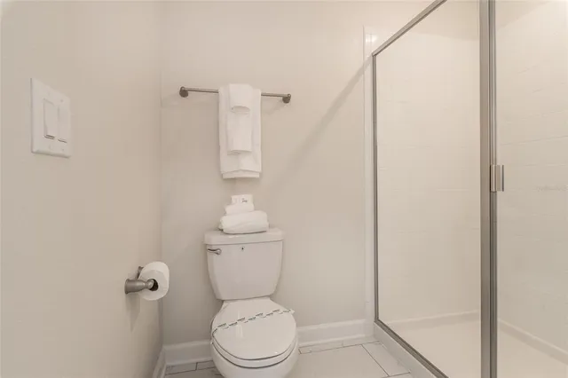 a white toilet sitting next to a shower