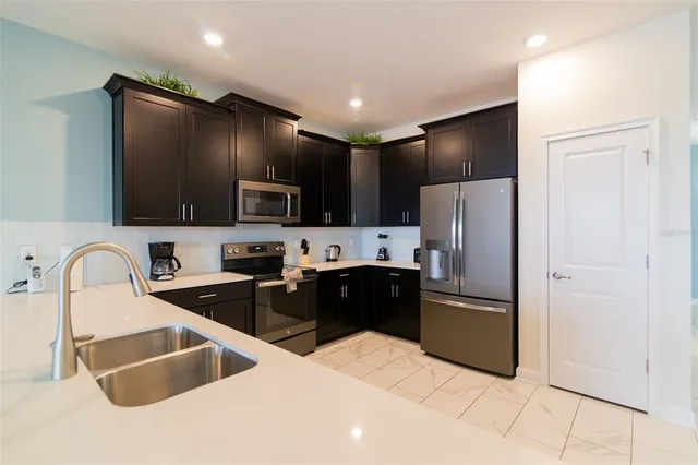 a kitchen with granite countertop a refrigerator and a sink