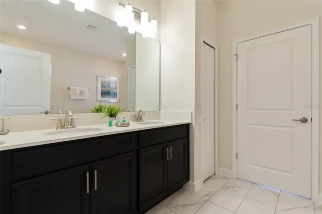a bathroom with a double vanity sink and a mirror