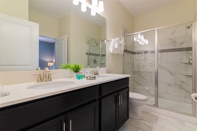 a bathroom with a double vanity sink toilet and shower