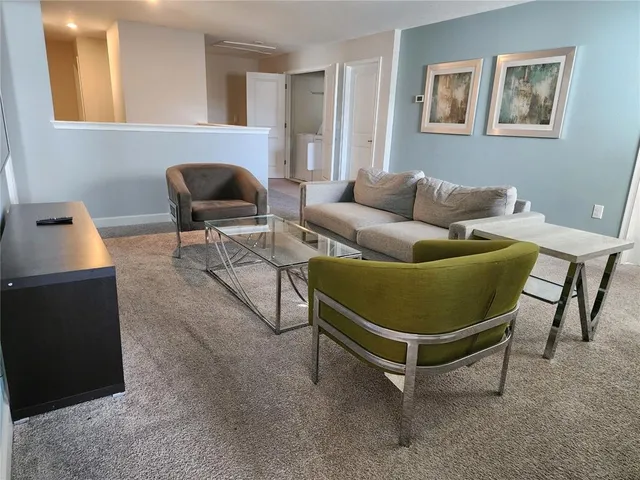 a living room with furniture and a air conditioner vent