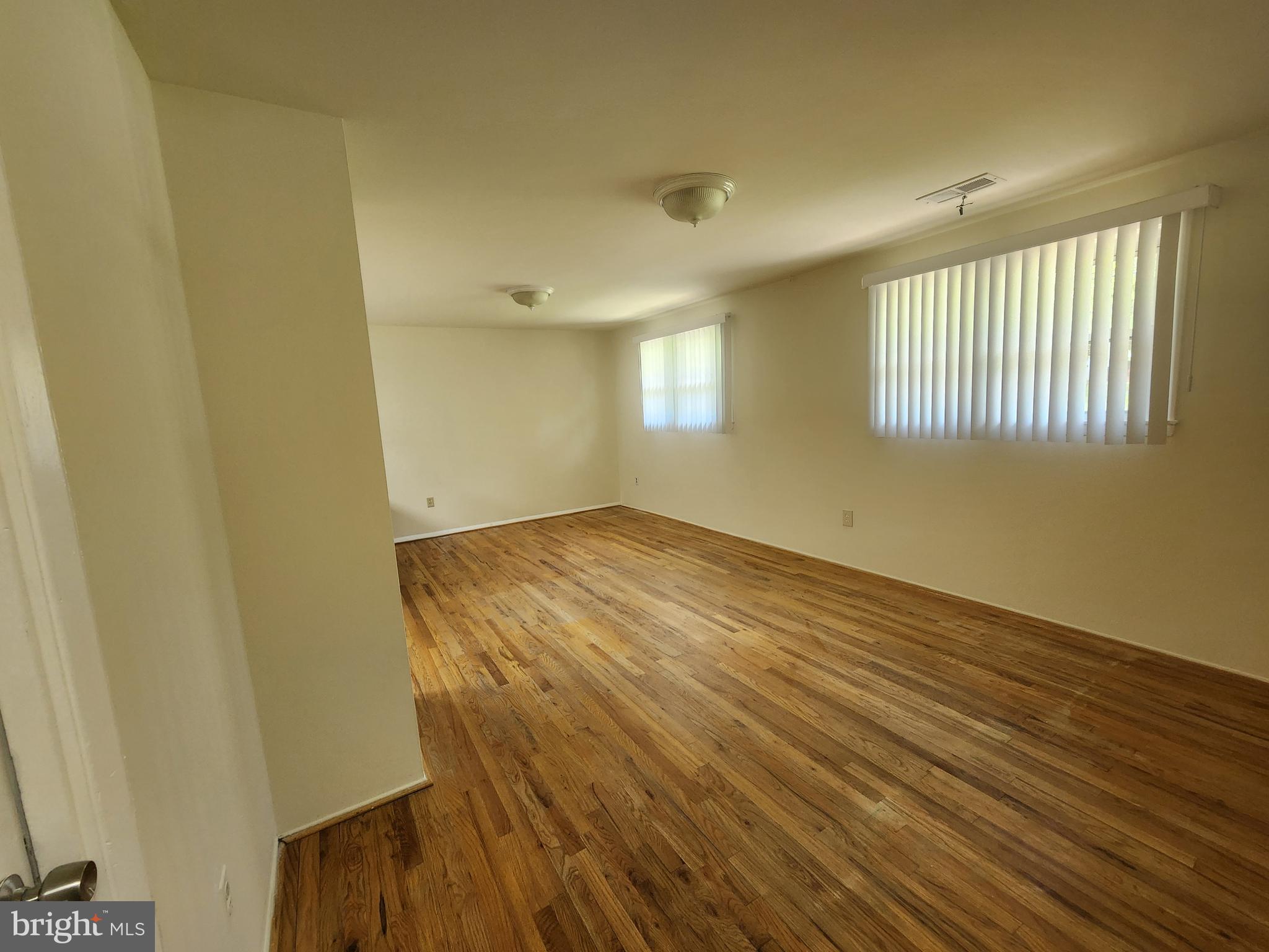 13416 Tamarack Road Silver Spring, MD 20904 - Photo 8 of 21 an empty room with wooden floor and windows