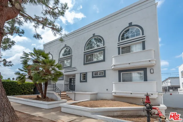 a front view of a building with lot of cars