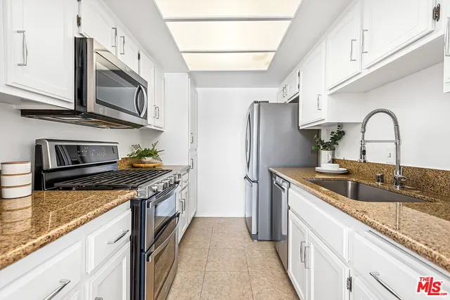 a kitchen with stainless steel appliances granite countertop a sink and stove