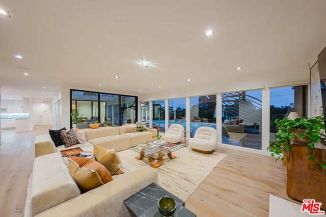 a living room with furniture and potted plants