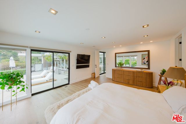 a spacious bedroom with a bed and a view of kitchen