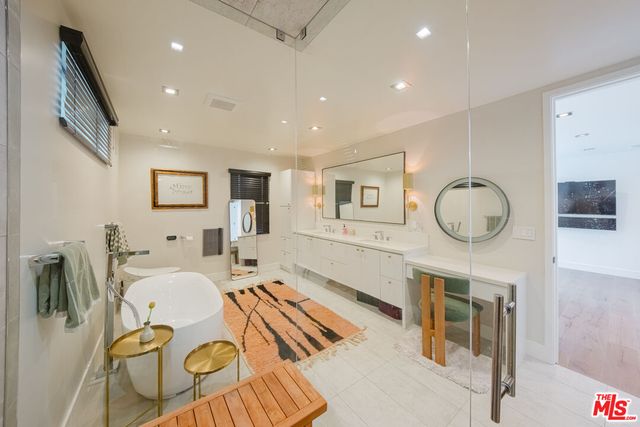 a spacious bathroom with a double vanity sink a mirror and a bathtub