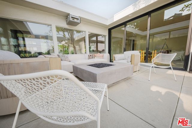 a view of a roof deck with couches and sky view