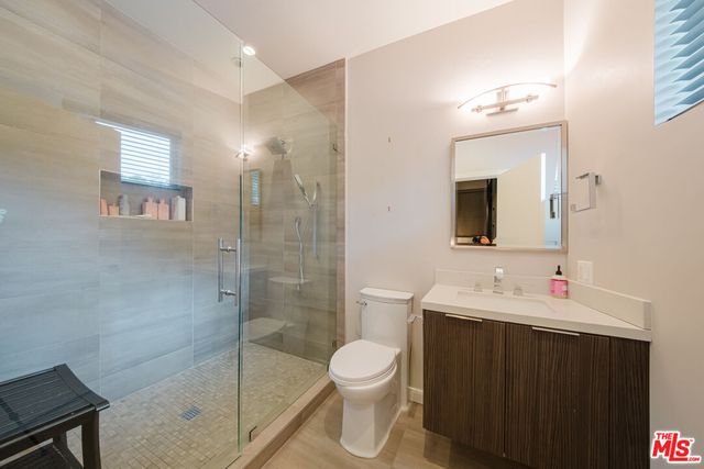 a bedroom with bed and a flat tv screen on dresser