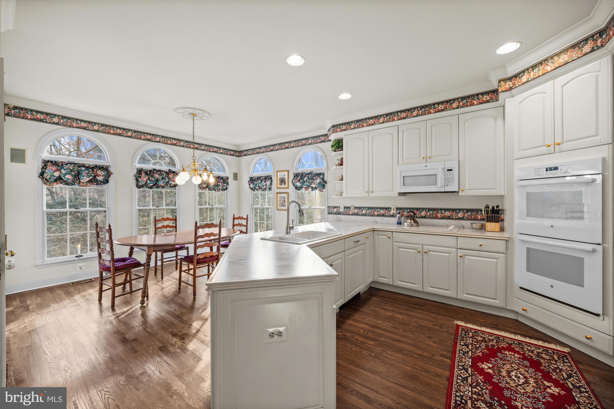 4 Independence Way Southampton, NJ 08088 - Photo 10 of 25 a kitchen with granite countertop a stove a sink dishwasher a dining table and chairs with wooden floor