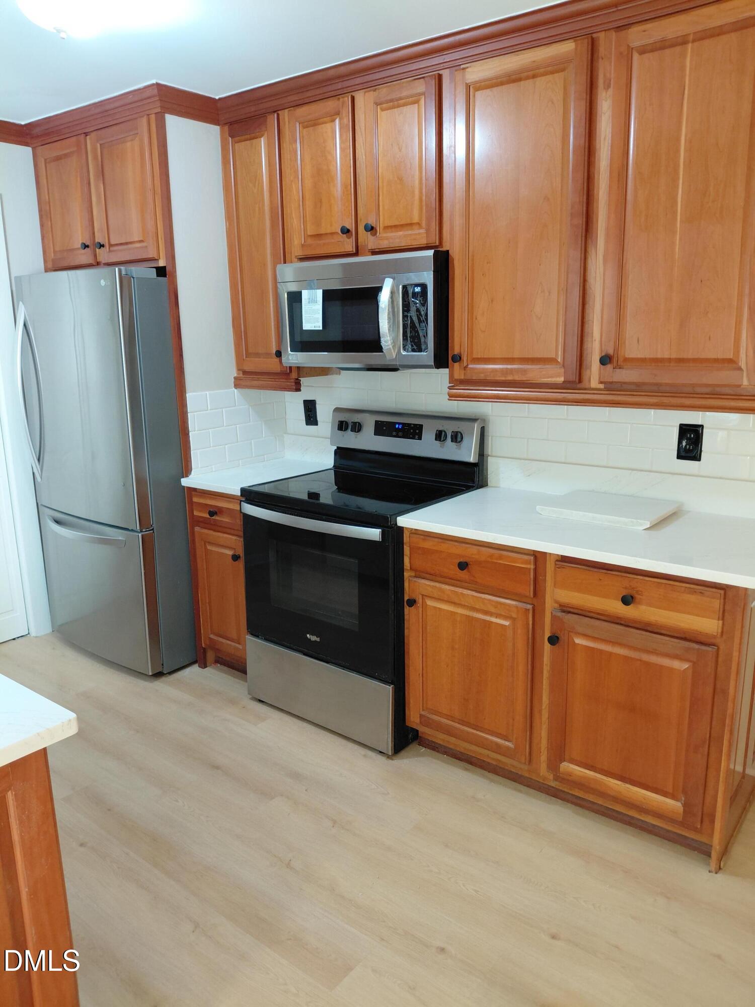 804 Olive Street Apex, NC 27502 - Photo 14 of 60 a kitchen with stainless steel appliances granite countertop a refrigerator stove and sink