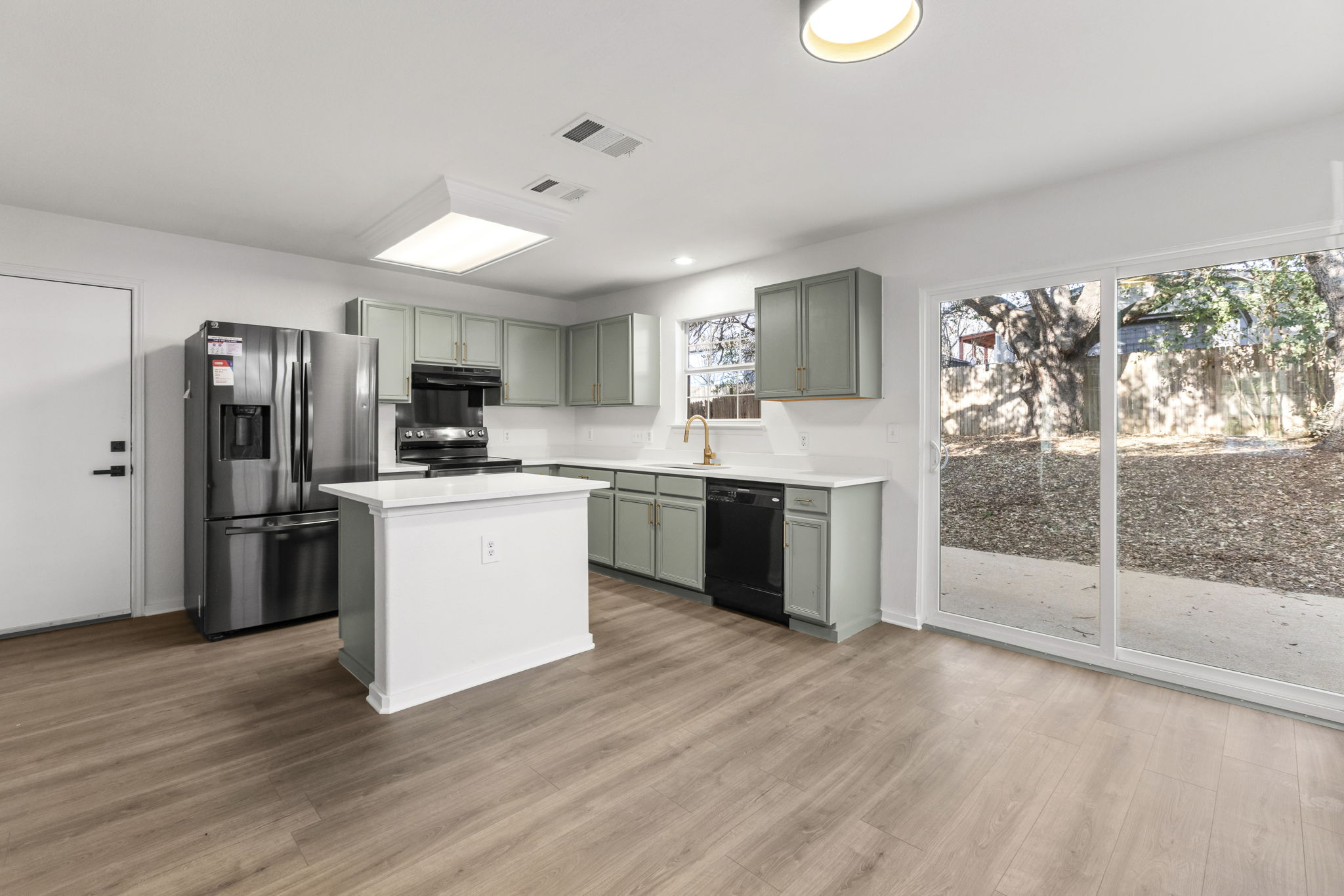 2110 Nogales Trail Austin, TX 78744 - Photo 11 of 36 Kitchen with stainless steel appliances, a center island, light wood-style flooring, recessed lighting, and under cabinet range hood